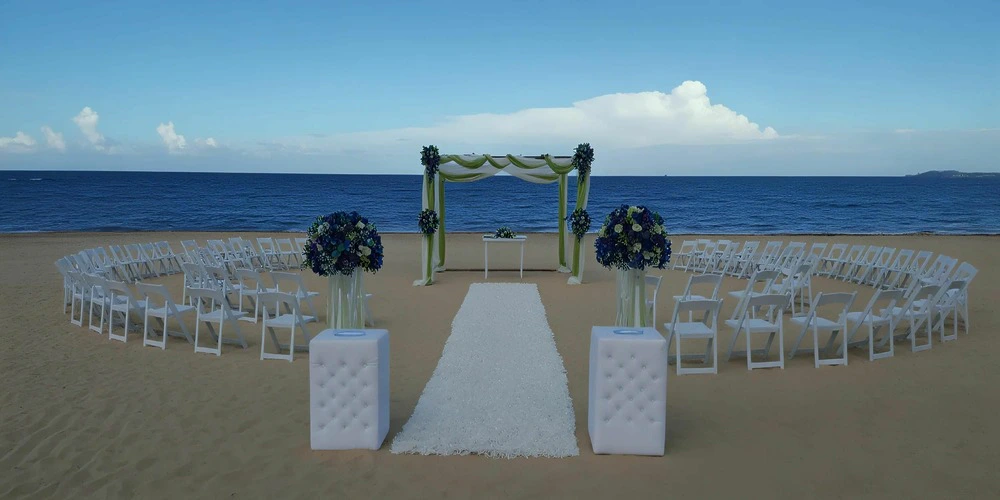Beach wedding ceremony setup with arch and white aisle overlooking the ocean at Dreams Onyx Resort & Spa