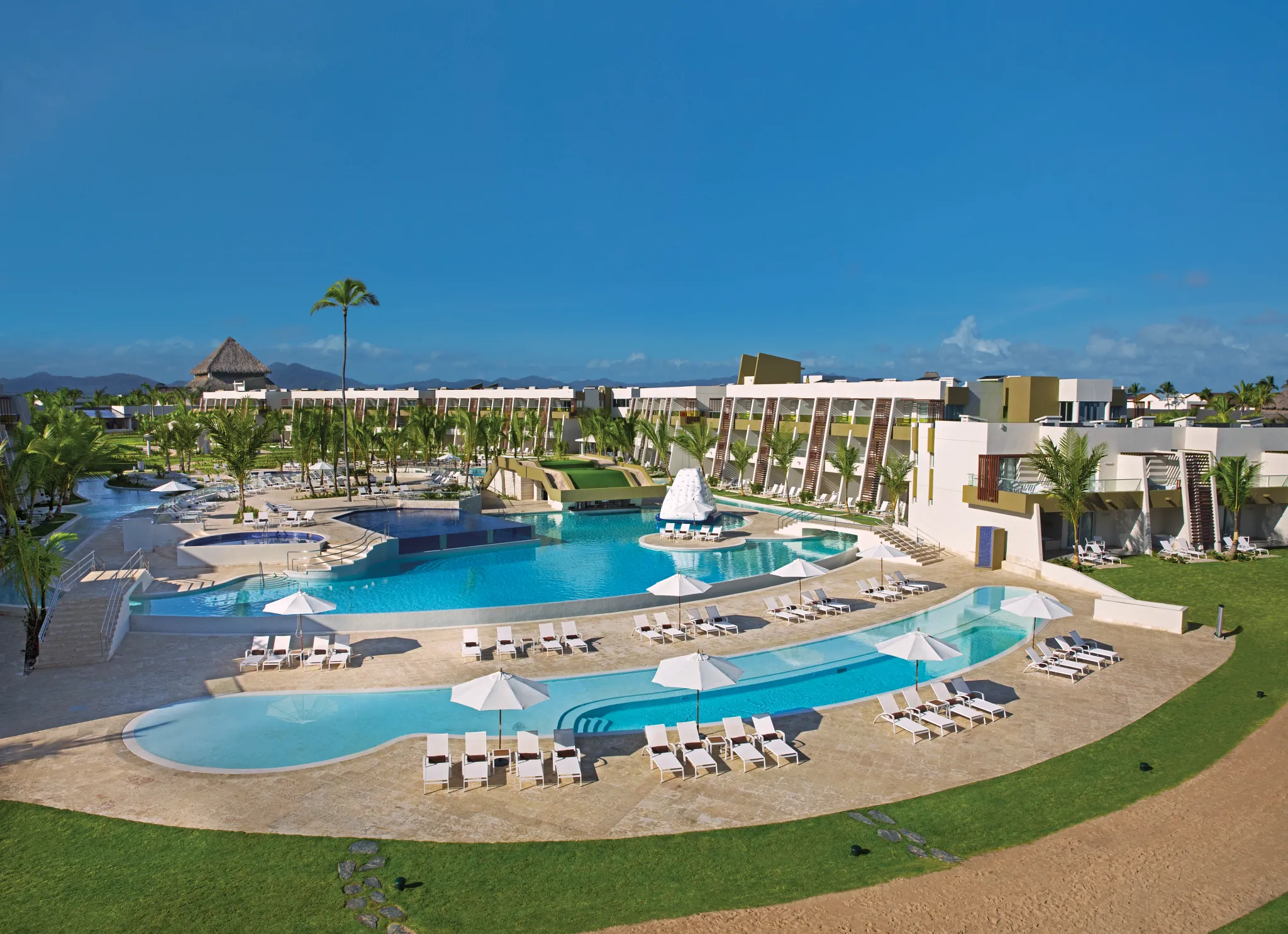 Expansive main pool with sun loungers, umbrellas, and tropical landscaping at Dreams Onyx Resort & Spa in Punta Cana.