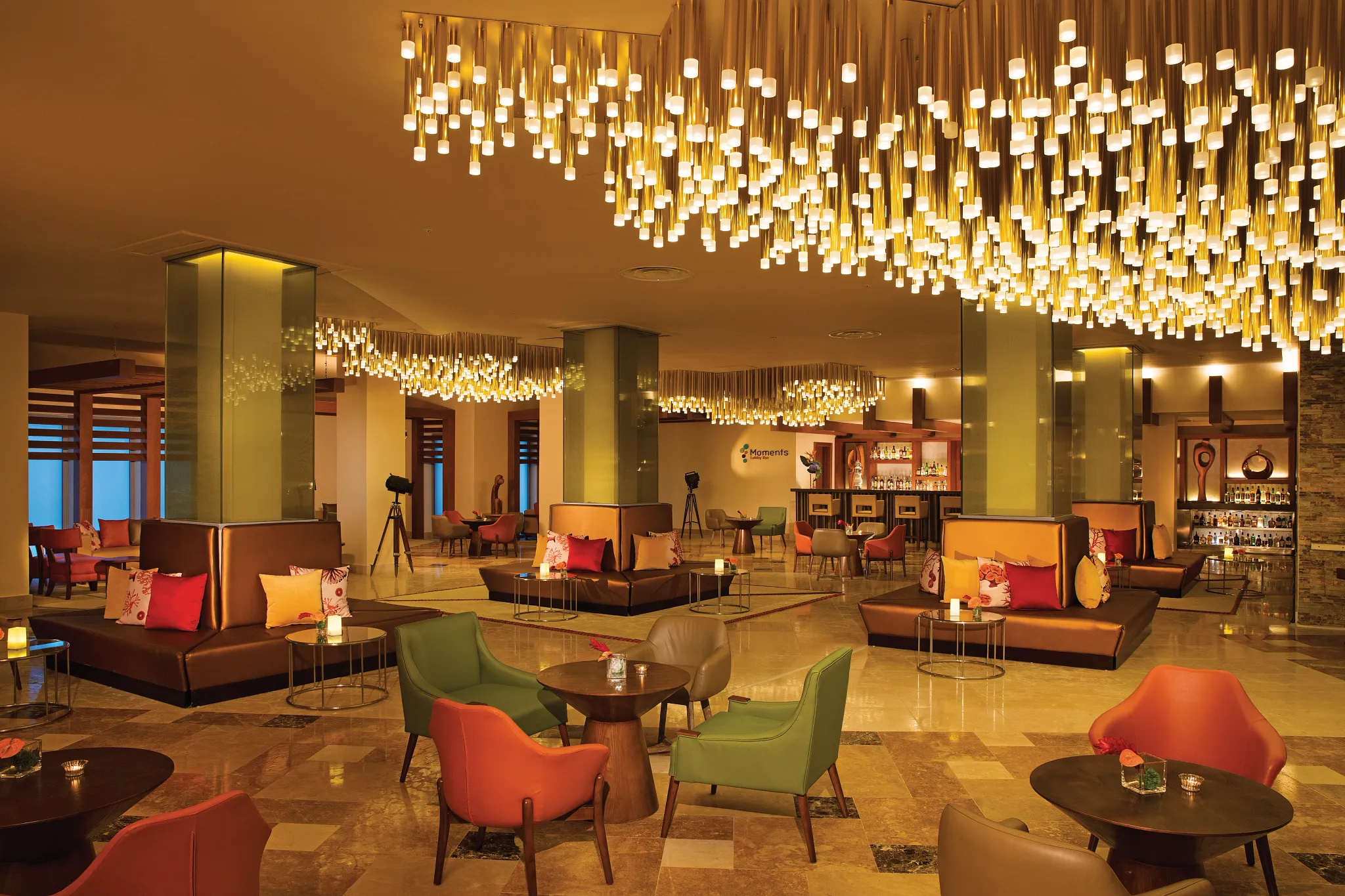 Moments Lobby Bar at Dreams Onyx Resort & Spa featuring stylish lounge seating, handcrafted cocktails, and a welcoming open-air lobby atmosphere.