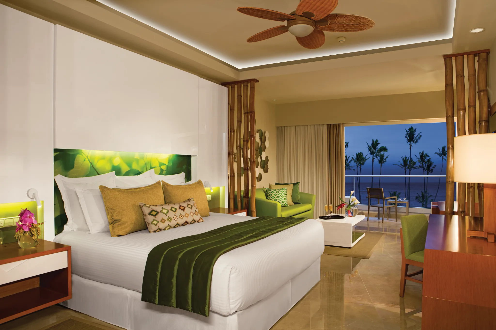 Preferred Club Junior Suite Ocean View with king bed at night and balcony view at Dreams Onyx Resort & Spa.
