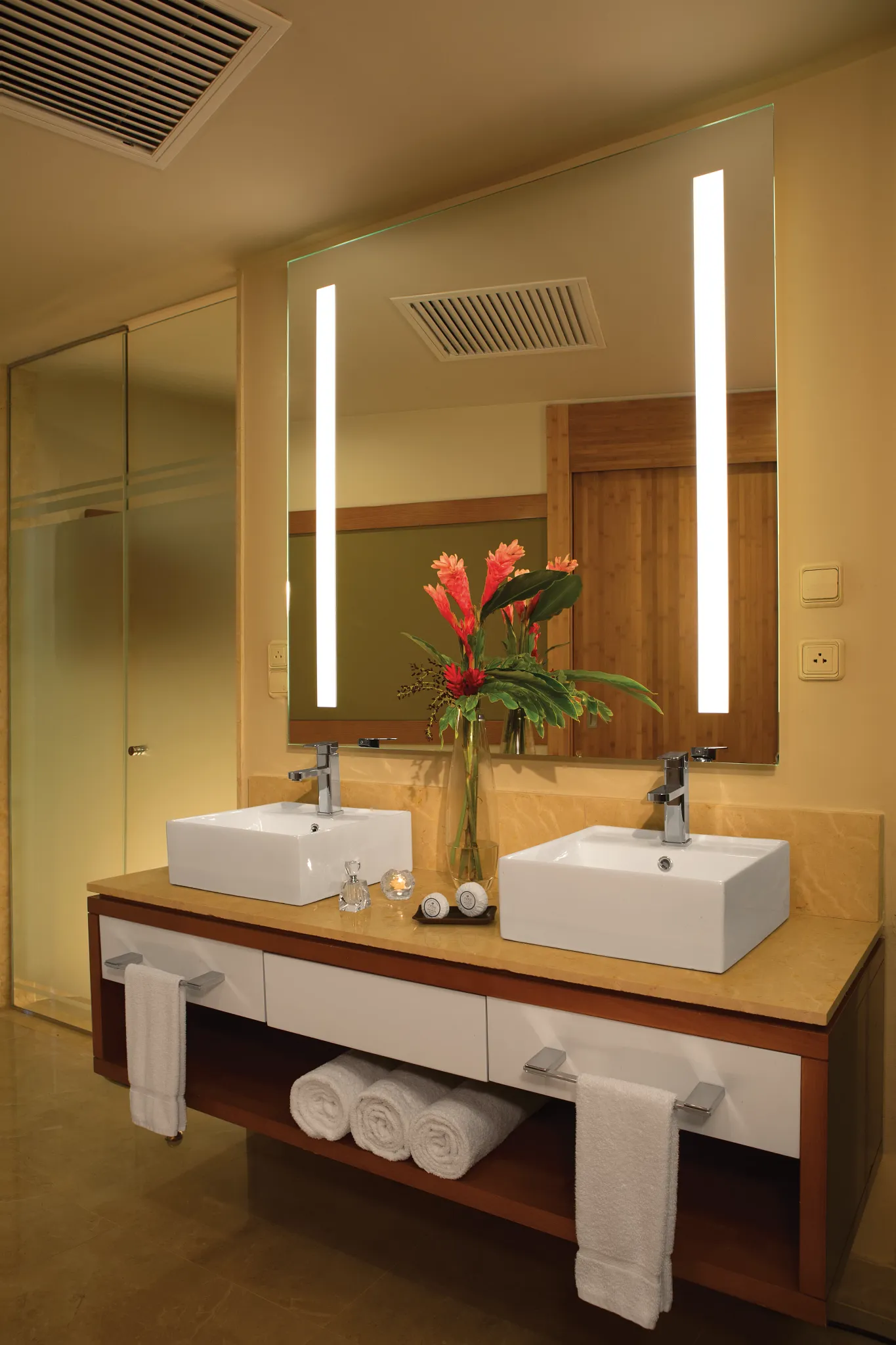 Preferred Club Junior Suite Swim-Up bathroom with double sinks and illuminated mirror at Dreams Onyx Resort & Spa.
